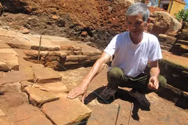 Archaeologist Nguyen Chieu examines a stone which he identified as the step to an entrance of a Cham tower in Qua Giang village in Da Nang city (Photo: VNA)