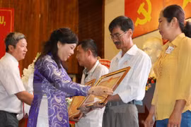 Minister Nguyen Thi Kim Tien (in purple dress) presents insignias for organ donors (Source: VNA)