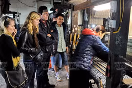 Foreigners visit a silk workshop at the Van Phuc silk village in Hanoi (Photo: VNA)