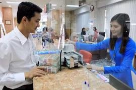 A customer conducts a transaction at a branch of Vietinbank in HCM City. Bank savings remain a good choice due to low inflation. (Photo: VNA)