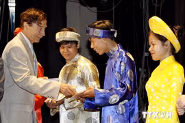 Prof. Odon Vallet presents scholarships to student during a granting ceremony at Opera House in Hanoi on August 24. Photo: VNA