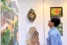 A visitor to the Hong Kong art expo watches Vietnamese products on display. (Photo: VNA)