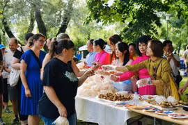 Visitors to the Vietnamese Culture Day event have some Vietnamese food. (Photo: VNA broadcasts)