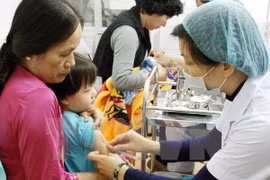 A vaccine shot is given to children. (Photo: VNA)