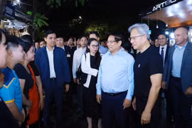 Vietnamese Prime Minister Pham Minh Chinh (third, right), and President and CEO of NVIDIA Jensen Huang (second, right) talk with local residents and visitors in Hanoi on December 5 night. (Photo: VNA)