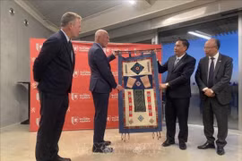 Deputy Secretary of the Party Committee of the northern moutainous province of Lao Cai Hoang Giang (second, R) presents souvenirs to a leader of the Nouvelle Aquitaine region. (Photo: VNA)