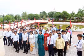 Vietnamese in Laos offer incense and flowers to President Ho Chi Minh. (Photo: VNA)