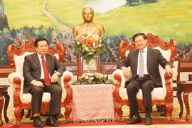 General Secretary of the Lao People's Revolutionary Party (LPRP) Central Committee and President of Laos Thongloun Sisoulith (R) receives Politburo member, President of the Ho Chi Minh National Academy of Politics (HCMA) and Chairman of the Central Theoretical Council Nguyen Xuan Thang on November 26. (Photo: VNA)