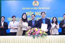 Leader of the Bac Giang provincial Confederation of Labour signs a cooperation agreement on welfare programme for union members and workers with HOGI Group (Photo: VNA) 