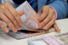 Counting Thai baht at Krung Thai Bank in Bangkok. (Photo: AFP/VNA)