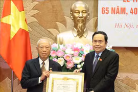 Politburo member, Secretary of the Party Delegation to the National Assembly (NA) and NA Chairman Tran Thanh Man (R) presents the 65-year Party membership badge to Nguyen Van An, former Politburo member and former Chairman of the NA. (Photo: VNA)