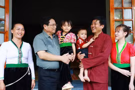 Prime Minister Pham Minh Chinh (2nd from left) visits the family of Xa Van Vong (2nd from right) in Son Phu hamlet, Cao Son commune, Da Bac district, Hoa Binh province, who recently moved into new homes as part of the temporary housing eradication initiative. (Photo: VNA)
