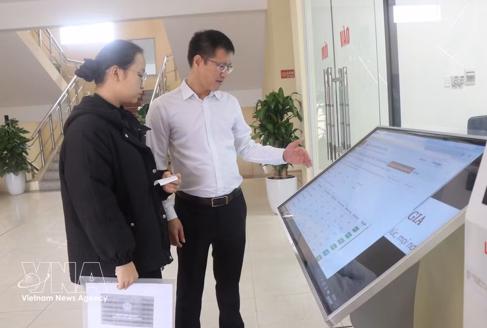 A civil servant guides a resident in Tam Son ward, Bac Ninh province, through administrative procedures. (Photo: VNA)