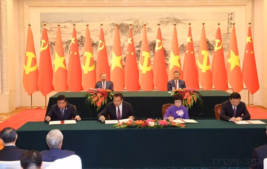 Party General Secretary and President of Vietnam To Lam and Party General Secretary and President of China Xi Jinping witness the signing ceremony of a cooperation agreement between the Vietnam News Agency (VNA) and Xinhua News Agency (on the right), as well as a memorandum of understanding on promoting cooperation projects in the social and public sectors between the Vietnamese Ministry of Planning and Investment and the Chinese National Administration of International Development Cooperation (on the left) in China (August 19, 2024). (Photo: VNA)