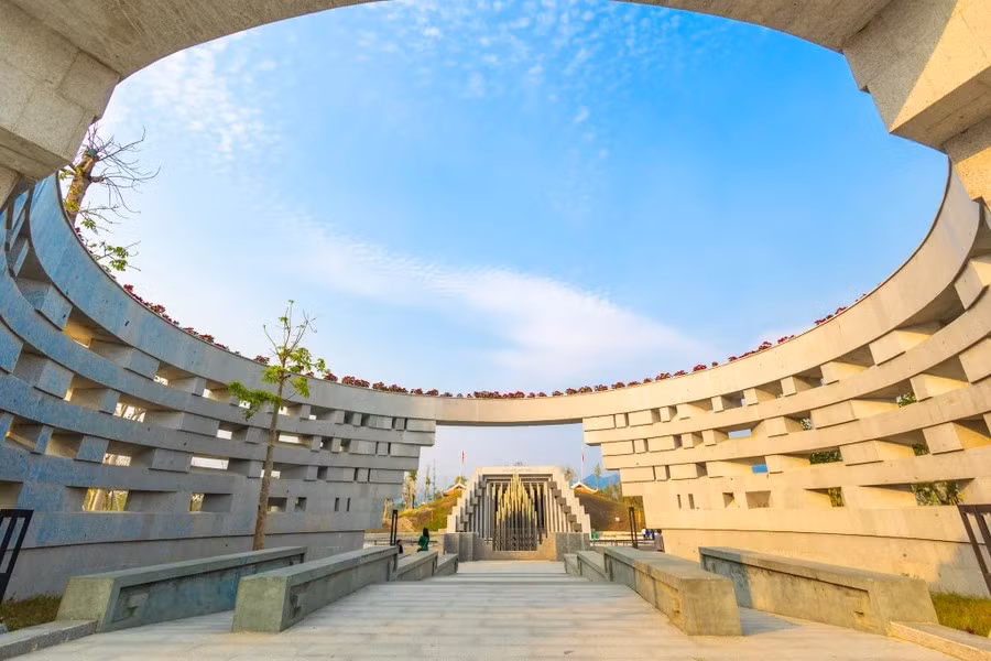 Entrance No. 1 is a curved wall with many holes resembling trenches. Visitors passing through can readily imagine gun muzzles from French foxholes, and sense that the Vietnamese soldiers were beginning to face danger. Above is a circular shape creating an open space interacting with the sky. (Photo: Vietnam+)