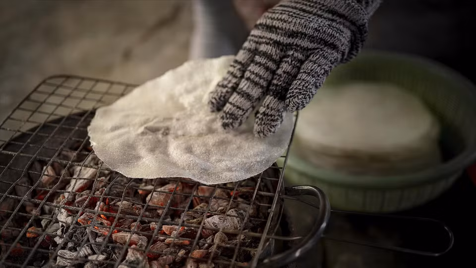 While the steamed rice rolls are still hot, a thin layer of rice paper is placed on top, then grilled until crispy. Then just fold the roll and enjoy it. (Photo: Vietnam Pictorial)