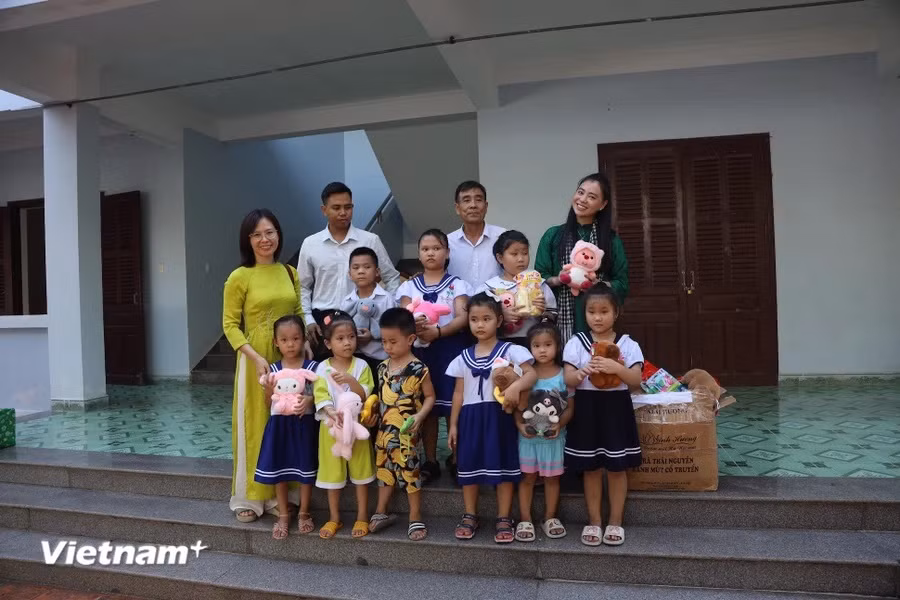 The members of the working group and the children on Truong Sa island pose for a group photo. (Photo: Vietnam+)