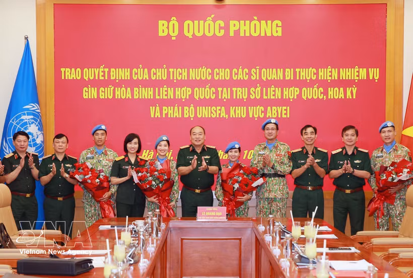 Senior Lieutenant General Le Quang Dao, Deputy Chief of the General Staff of the Vietnam People's Army, four officers assigned to UN peacekeeping missions, and delegates pose for a group photo. (Photo: VNA) 