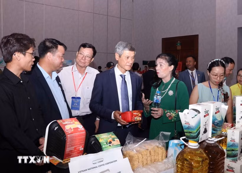 Vietnamese Ambassador to Cambodia Nguyen Minh Vu and Cambodian businesspeople visit the Vietnamese booth. (Photo: VNA)