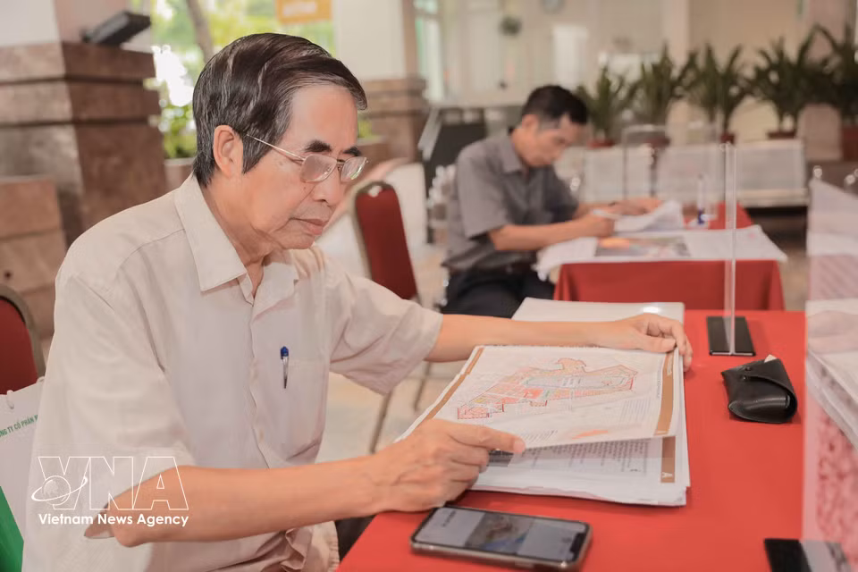 Residents not only submit feedback but also take photos of the proposed plans and designs for further study. (Photo: Phan Phuong/VNA)