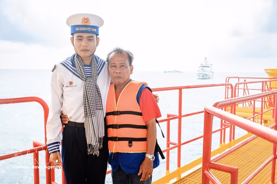 Soldier Pham Hong Duc Anh and his father, Pham Hong Diem from Phu My ward, Ho Chi Minh City, capture a memorable moment together on the DK1/10 platform. (Photo: VNA)