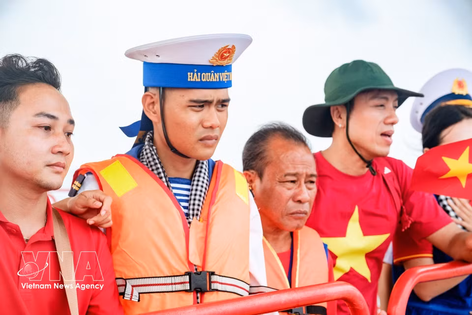 Soldier Pham Hong Duc Anh and his father join artists from the Ho Chi Minh City delegation during a visit to the DK1/10 platform. (Photo: VNA)