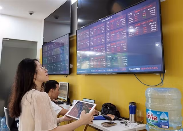 Investors observe stock movements on a trading floor of a securities firm in Hanoi. (Photo: VNA) 