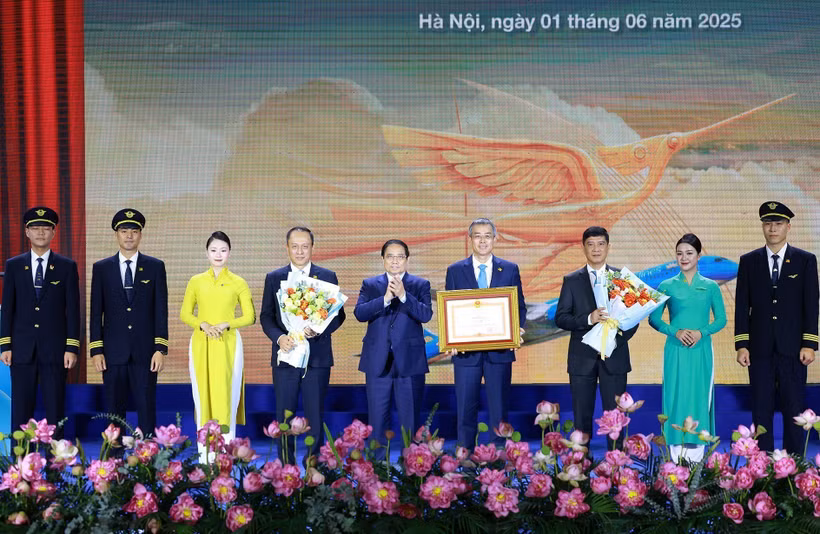 Prime Minister Pham Minh Chinh awards a certificate of merit to Vietnam Airlines. (Photo: VNA)