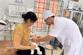 A doctor at Trung Nguyen Medical Station in Te Lo commune, Phu Tho province, examines a child patient. (Photo: VNA)