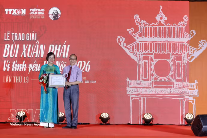 VNA General Director and Vice Chairwoman of the Party Central Committee’s Commission for Publicity Vu Viet Trang hands over the Grand Prize to poet Bang Viet at the ceremony (Photo: VNA)