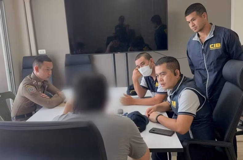 Police question one of the 11 suspects arrested during a raid on five illegally operating e-money firms in Bangkok and two other provinces on Friday. (Photo: bangkokpost.com) 
