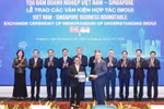 Party General Secretary To Lam and officials witness the exchange of cooperation documents between Vietnamese and Singaporean firms at a business roundtable in the city state on March 13. (Photo: VNA)