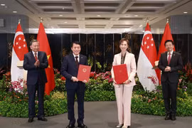 Party General Secretary To Lam (L) and Singaporean PM Lawrence Wong (R) witness the exchange of a MoU on digital transformation between the Vietnamese Ministry of Public Security and the Singaporean Ministry of Digital Development and Information on March 12. (Photo: VNA)